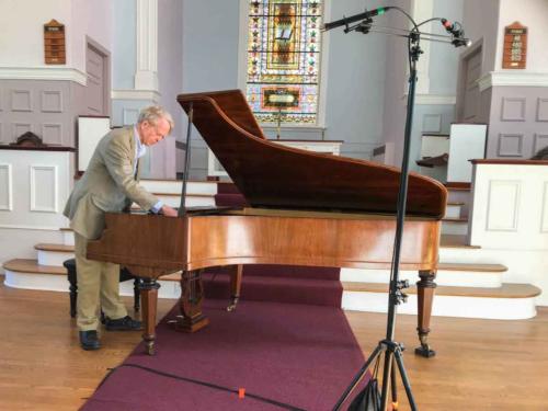 Michael Frederick prepares the 1859 Érard for a recital in the Community Church